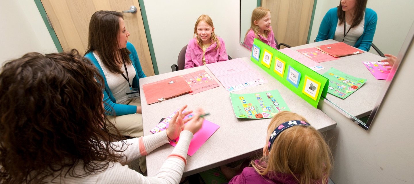 Students working with children at a table